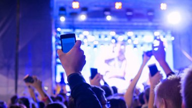 Gece açık hava konserinde sahne önünde parti gençler siluet