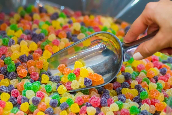 Nő figyelembe színes ízletes lekváros cukorka - közelkép — Stock Fotó