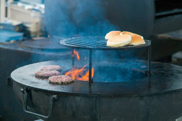 Processo de preparação de hambúrgueres no festival de comida de rua — Fotografia de Stock