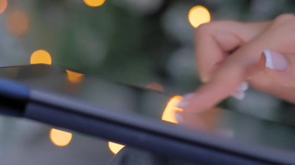 Mujer usando tableta de pantalla táctil, fondo de luz de Navidad - de cerca — Vídeo de stock