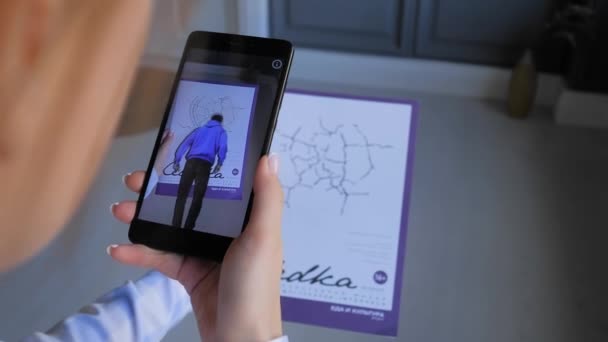 Femme tenant un magazine et utilisant un smartphone avec application AR — Video