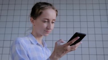 Akıllı telefon tutan ve ses tanıma fonksiyonu kullanan kadın