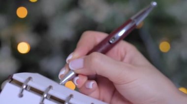 Klasik defter düzenleyicisiyle yapılacaklar listesi hazırlamak için kadın eli kalem ve yazı.