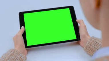 Kafede yeşil ekranlı tablet bilgisayar arayan kadın