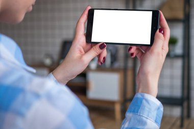 Beyaz boş ekranlı akıllı telefona bakan kadın