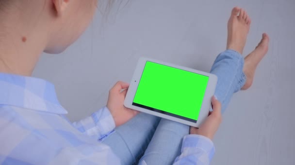 Mujer mirando a la tableta con pantalla verde en blanco - maqueta de concepto — Vídeos de Stock