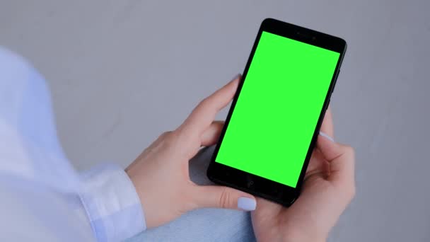 Mujer sosteniendo teléfono inteligente negro con pantalla verde en blanco - concepto de copyspace — Vídeo de stock