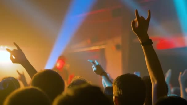 Siluetas de personas festejando en el concierto de rock frente al escenario - cámara lenta — Vídeo de stock