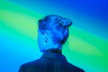 Çok renkli ışık aydınlatmaile modern sergiye bakan kadın