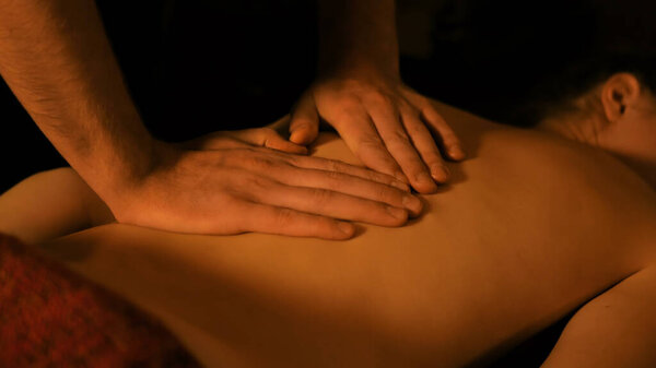 Профессиональный массажист-мужчина делает массаж для клиентки в спа-салоне