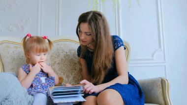 Genç anne ve küçük kızı fotobook 'a benziyorlar.