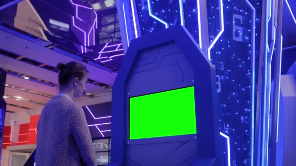 Жінка дивиться на порожній зелений кіоск на виставці концепція зеленого екрану — стокове відео