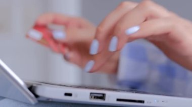 Kadın elleri online alışveriş için dizüstü bilgisayar klavyesi ve kredi kartı kullanıyor