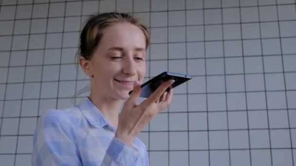 Wanita memegang smartphone dan menggunakan fungsi pengenalan suara — Stok Video