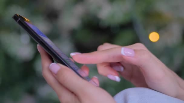 Mujer usando smartphone, fondo de luz de Navidad - de cerca — Vídeos de Stock