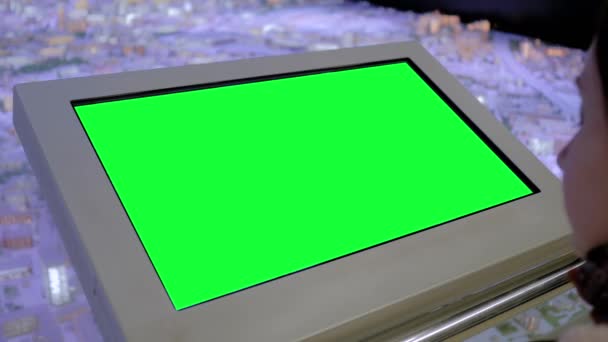 Vrouw op zoek naar blanco groene display kiosk op tentoonstelling - groen scherm concept — Stockvideo