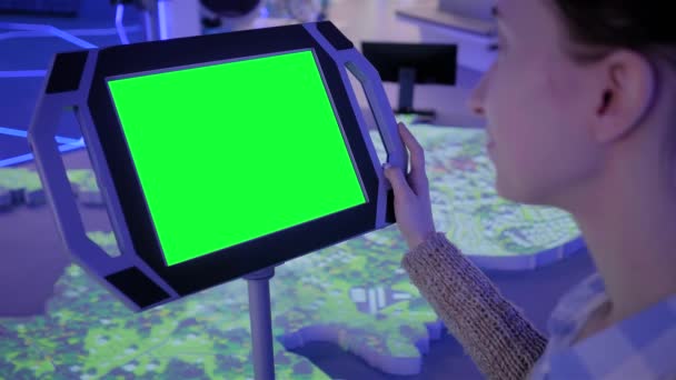 Close up view: woman using floor standing tablet kiosk with blank green display — Stock Video