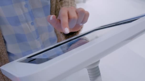 Woman hand using touchscreen display of floor standing white tablet kiosk — Stock Video