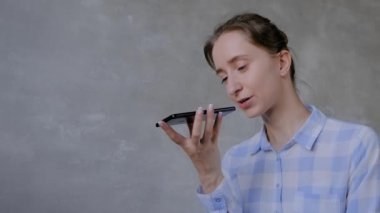 Akıllı telefon tutan ve ses tanıma fonksiyonu kullanan kadın
