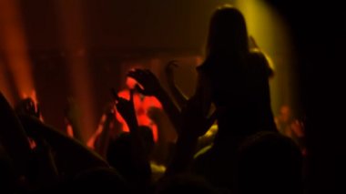 Süper yavaş çekim: insanlar sahne önünde konserde siluet partiler düzenliyor