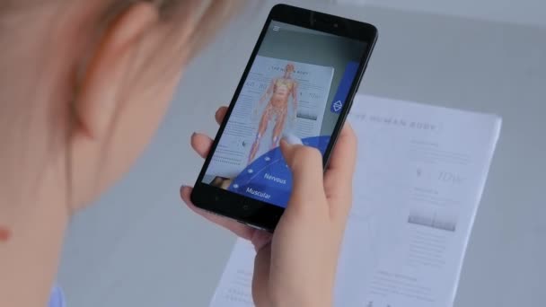 Жінка з використанням смартфона з розширеною реалією додатка: 3d модель системи людського тіла — стокове відео