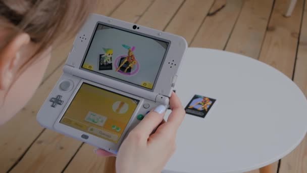 Mujer gamer utilizando la consola de juegos Nintendo 3ds con aplicación AR — Vídeo de stock