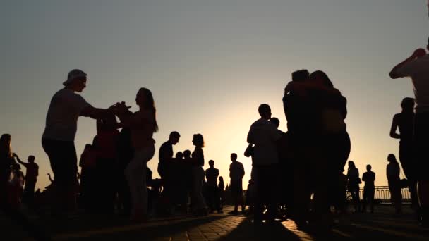 Силуети, які вчаться танцювати по місту на заході сонця - дуже повільний рух. — стокове відео