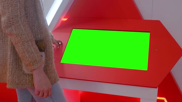 Groen scherm concept - vrouw op zoek naar lege groene display kiosk op tentoonstelling — Stockvideo