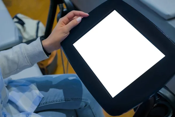 Woman looking at floor standing black tablet kiosk with blank white display