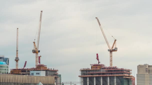 Timelapse de guindastes torre amarela em movimento e construção de edifícios inacabados — Vídeo de Stock