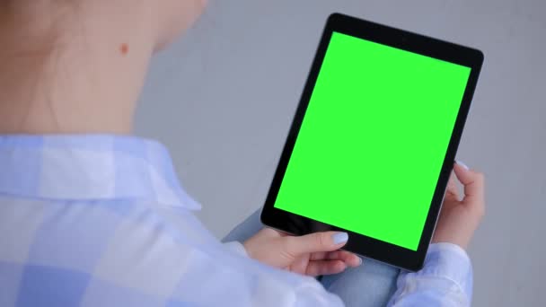 Жінка дивиться на планшетний комп'ютер з порожнім зеленим екраном - концепція ключа хроми — стокове відео