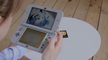 Oyun konsolu kullanan kadın oyuncu AR uygulaması ile Nintendo 3ds - görünümü kapat