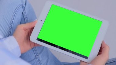 Görüntüyü kapat: boş yeşil ekranlı tablet kullanan kadın - krom anahtar kavramı