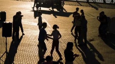 Romantik çiftler gün batımında gökyüzüne karşı dans ediyorlar - yavaş çekim