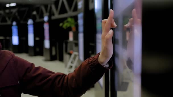 Woman using interactive touchscreen display of electronic multimedia kiosk — Stock Video