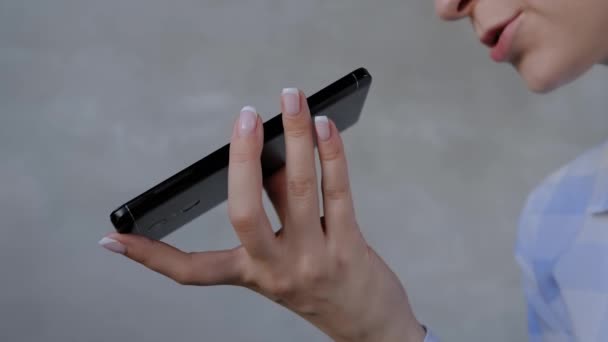 Жінка тримає смартфон і використовує функцію розпізнавання голосу крупним планом — стокове відео