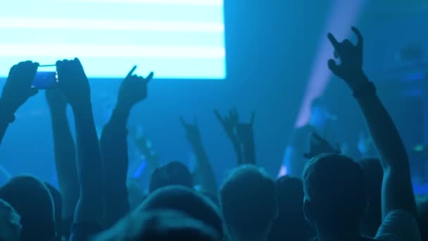 Cámara lenta: siluetas de gente festejando en un concierto de rock frente al escenario — Vídeos de Stock