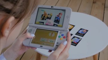 Oyun konsolu kullanan kadın oyuncu AR uygulaması ile Nintendo 3ds