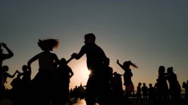 Romantik çiftler gün batımında gökyüzüne karşı dans ediyorlar - süper yavaş çekim