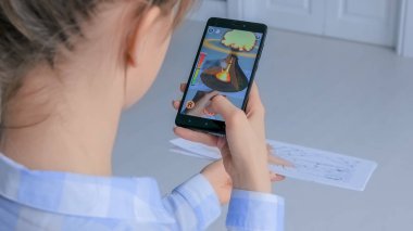 AR uygulamalı akıllı telefon kullanan kadın - sanal volkanik patlama