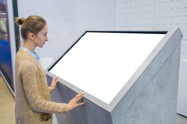 Sergide etkileşimli boş dokunmatik ekran kiosk kullanan kadın