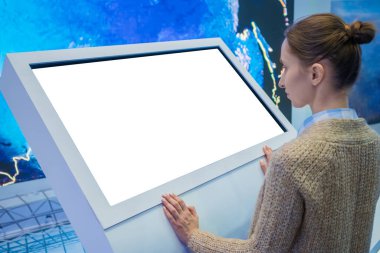 Sergide etkileşimli boş dokunmatik ekran kiosk kullanan kadın