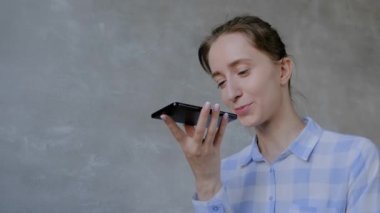 Akıllı telefon tutan ve ses tanıma fonksiyonu kullanan kadın