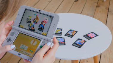 Oyun konsolu kullanan kadın oyuncu AR uygulaması ile Nintendo 3ds