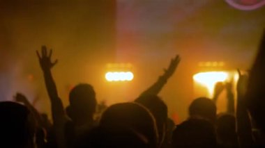 Yavaş çekim: Sahnenin önündeki rock konserinde parti yapan insanların siluetleri