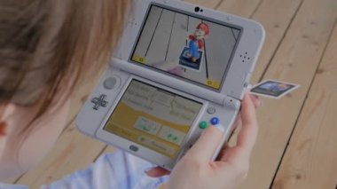 Oyun konsolu kullanan kadın oyuncu AR uygulaması ile Nintendo 3ds - görünümü kapat
