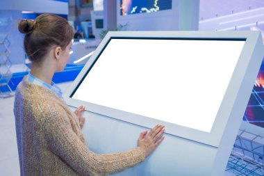 Sergide boş beyaz ekran kioskuna bakan kadın - beyaz ekran konsepti