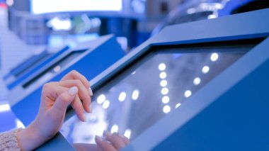 Teknoloji sergisinde etkileşimli dokunmatik ekran kullanan kadın