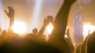 Yavaş çekim: Sahnenin önündeki rock konserinde parti yapan insanların siluetleri