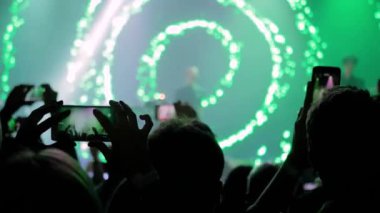 İnsanlar akıllı telefonlu canlı müzik konserinin fotoğrafını çekiyor ya da kaydediyor.